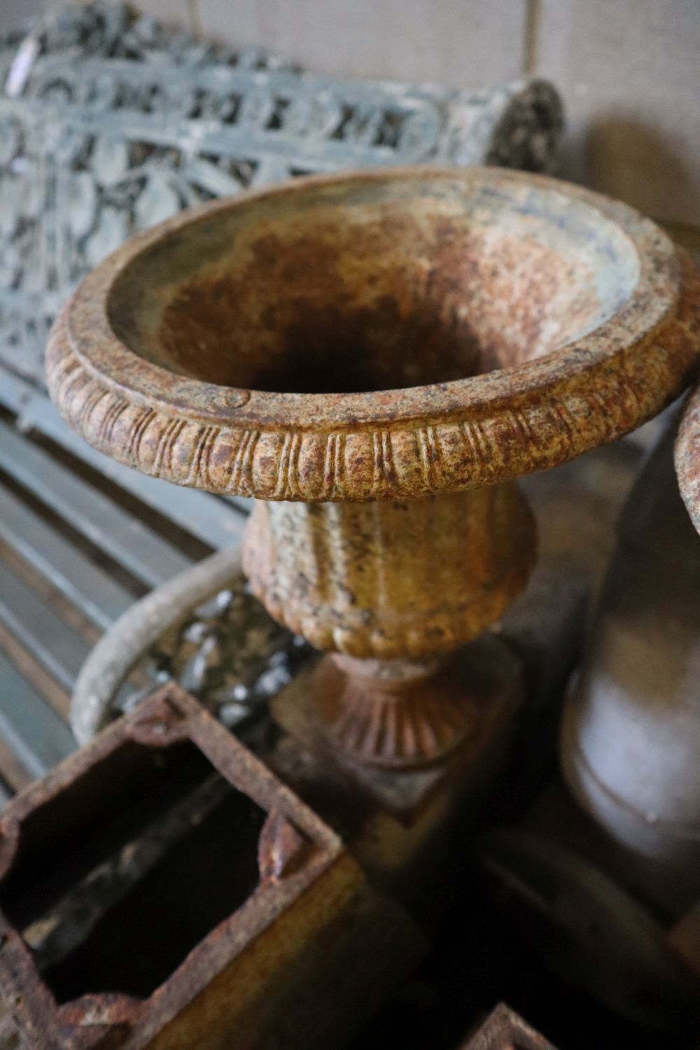 A pair of Victorian style cast iron campana garden urns on stands, height 49cm